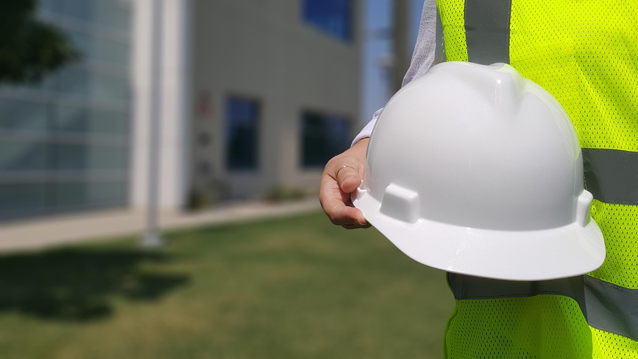 A licensed contractor holding a white hard hat in front of a new remodel